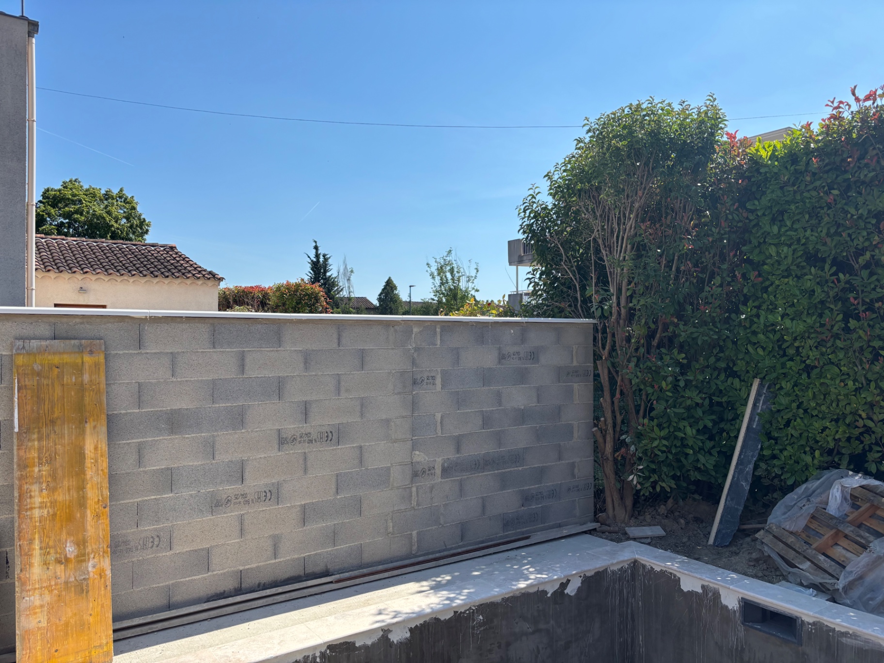 Mur de clôture en agglos le long du bassin de piscine