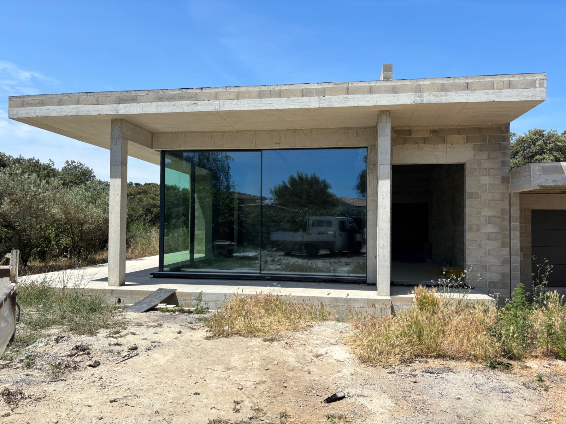 Villa contemporaine avec grande baie vitrée et débord de toit béton